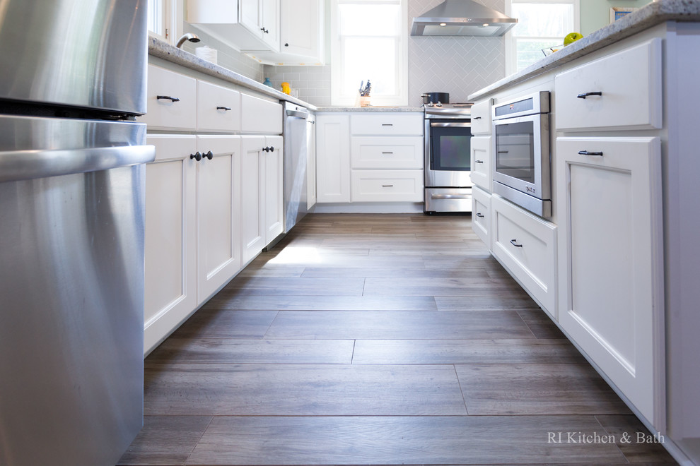 Eat-in kitchen - large transitional l-shaped porcelain tile eat-in kitchen idea in Providence with an undermount sink, recessed-panel cabinets, white cabinets, granite countertops, gray backsplash, ceramic backsplash, stainless steel appliances, green walls and an island