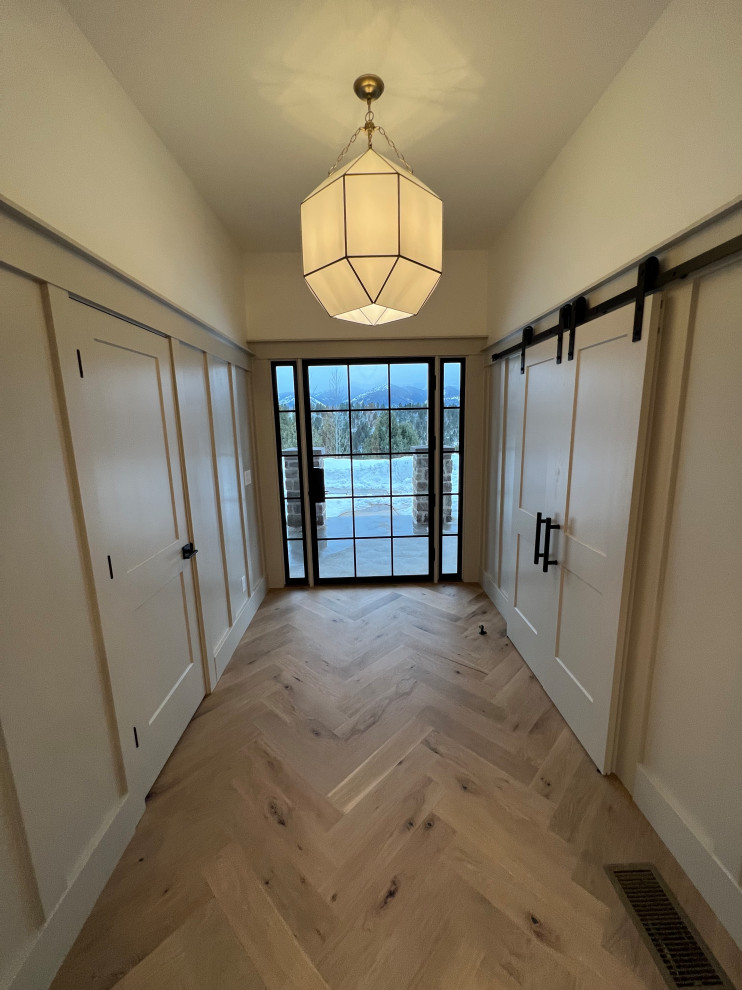 Inspiration for a mid-sized transitional light wood floor foyer remodel with beige walls and a glass front door