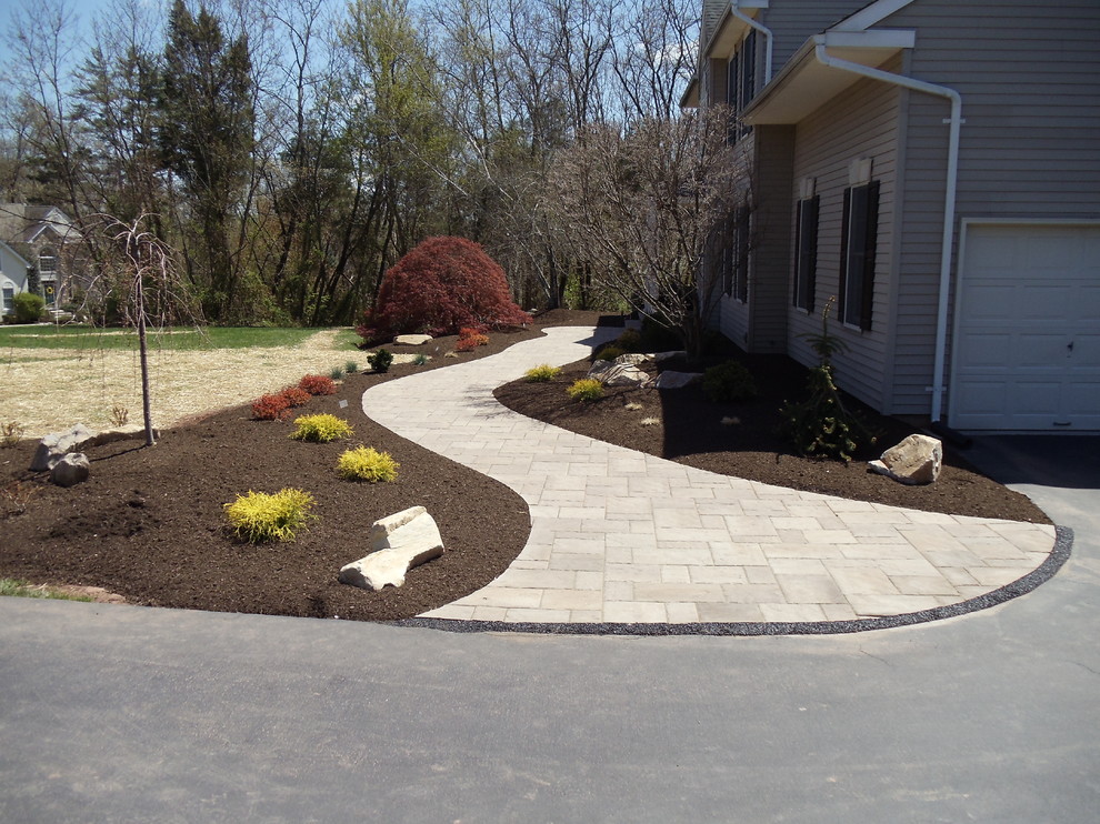This is an example of a mid-sized arts and crafts front yard partial sun garden in Philadelphia with a garden path and concrete pavers.