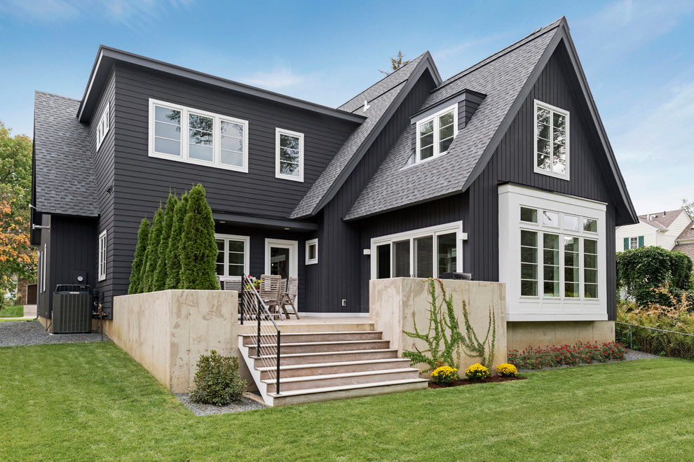 Photo of a mid-sized scandinavian two-storey black exterior in Minneapolis with concrete fiberboard siding and a gable roof.
