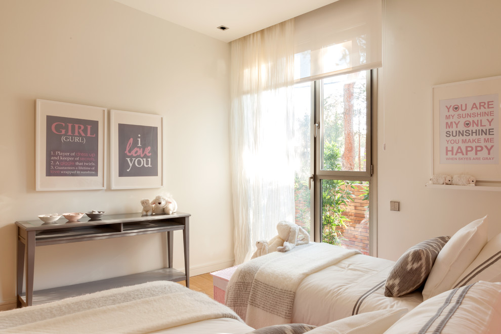 Nordisk inredning av ett mellanstort könsneutralt barnrum kombinerat med sovrum och för 4-10-åringar, med beige väggar och mellanmörkt trägolv