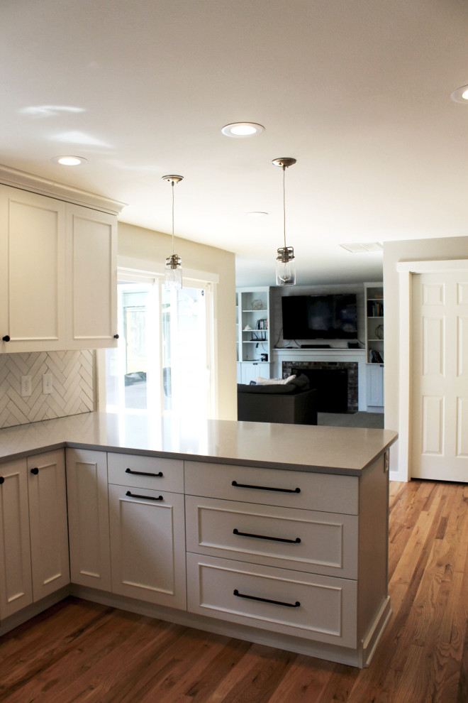 Mid-sized transitional u-shaped medium tone wood floor eat-in kitchen photo in Seattle with an undermount sink, shaker cabinets, white cabinets, quartz countertops, white backsplash, ceramic backsplash, stainless steel appliances, a peninsula and gray countertops