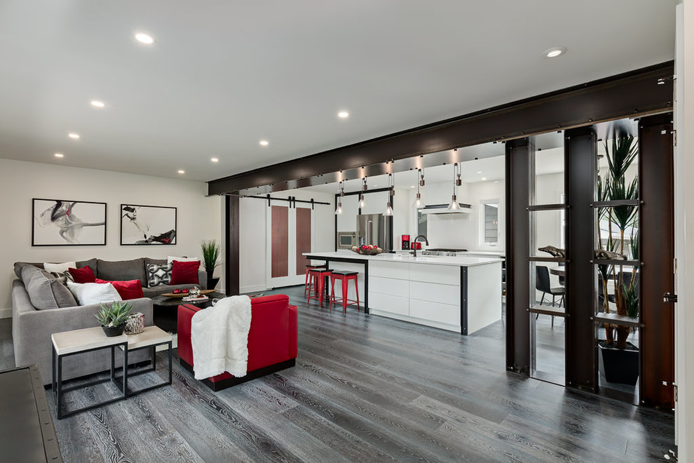 Design ideas for a large industrial open concept living room in Calgary with white walls and dark hardwood floors.