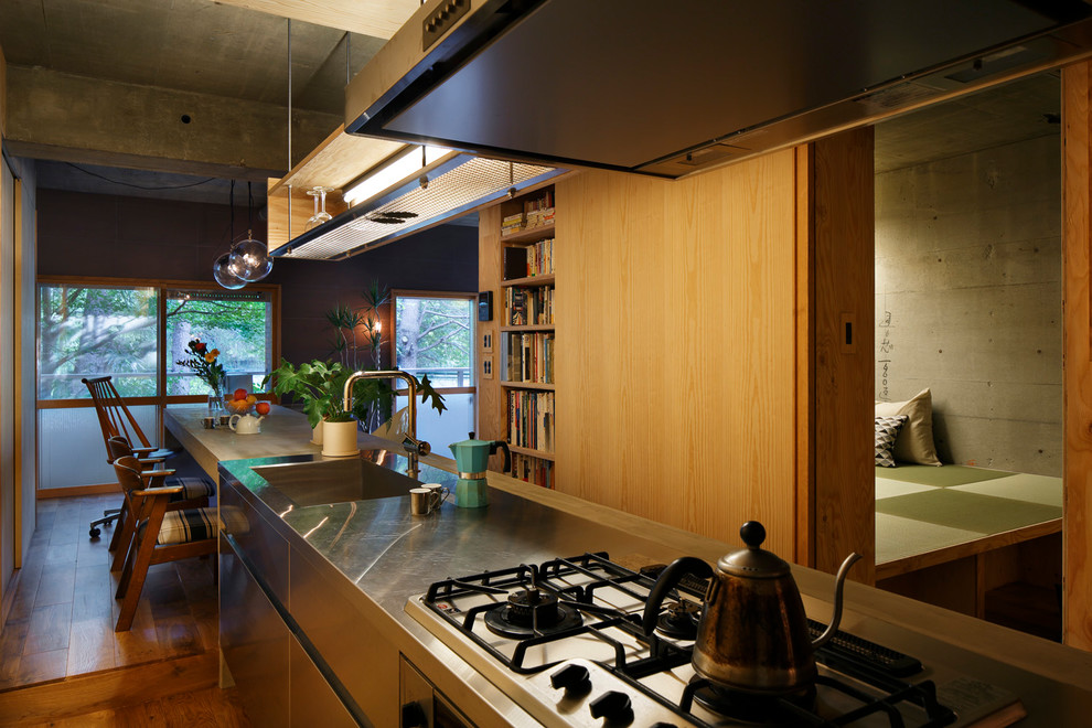 Inspiration for an asian kitchen in Tokyo with a single-bowl sink, flat-panel cabinets, stainless steel cabinets, medium hardwood floors, with island and brown floor.