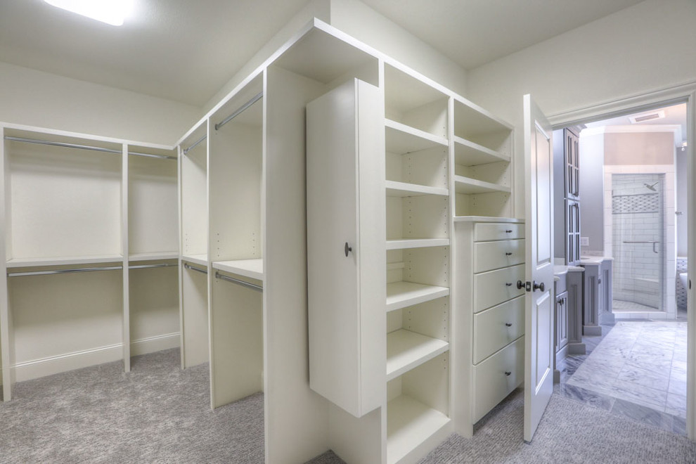 Small traditional gender-neutral built-in wardrobe in Houston with flat-panel cabinets, white cabinets, carpet and beige floor.