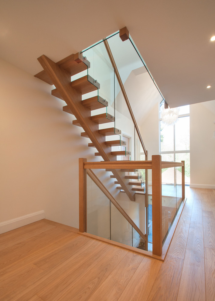 Inspiration for a mid-sized modern wood straight staircase in Buckinghamshire with wood risers and mixed railing.