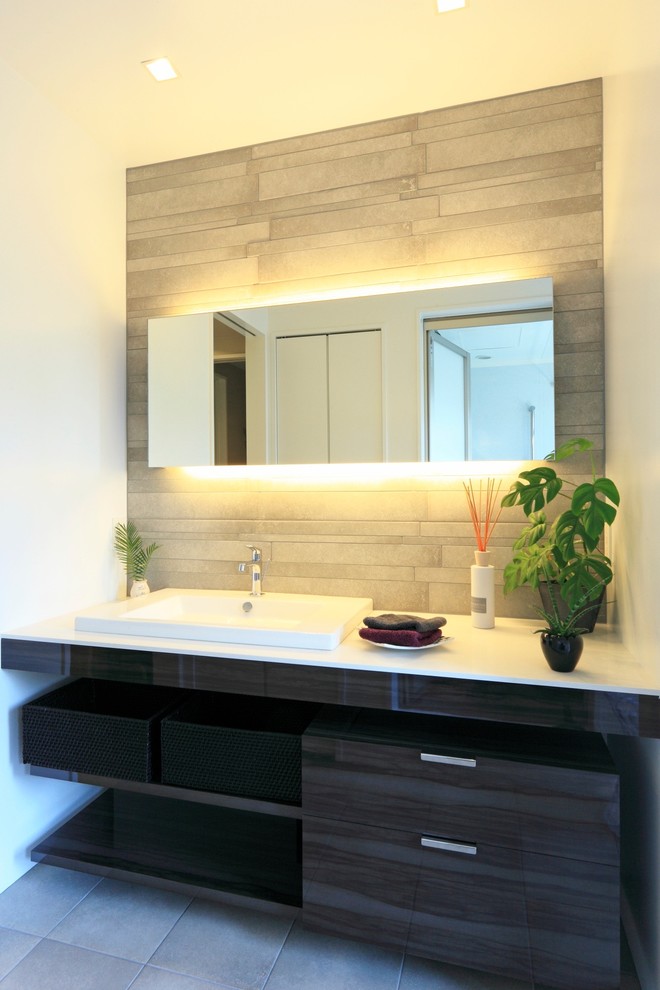 Contemporary powder room in Other with flat-panel cabinets, black cabinets, white walls, a drop-in sink and grey floor.