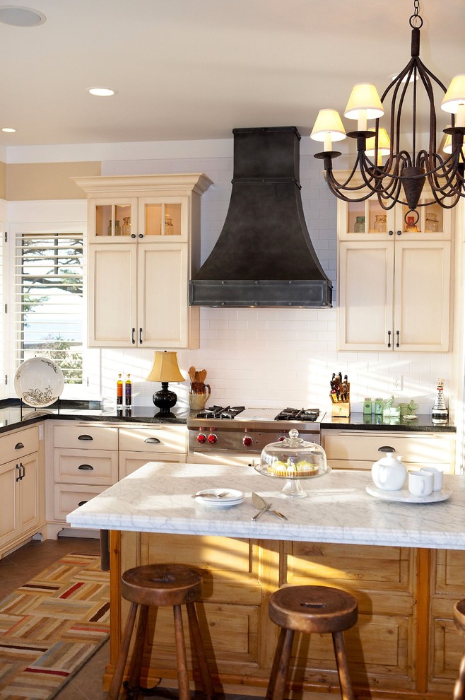 This is an example of a traditional kitchen in Seattle with recessed-panel cabinets, beige cabinets, white splashback and subway tile splashback.