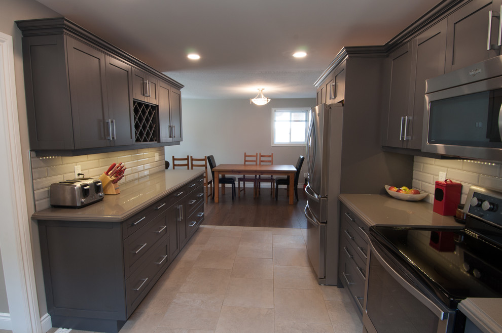 Mid-sized transitional u-shaped ceramic tile and beige floor enclosed kitchen photo in Toronto with a double-bowl sink, shaker cabinets, dark wood cabinets, quartzite countertops, beige backsplash, stainless steel appliances, no island and subway tile backsplash