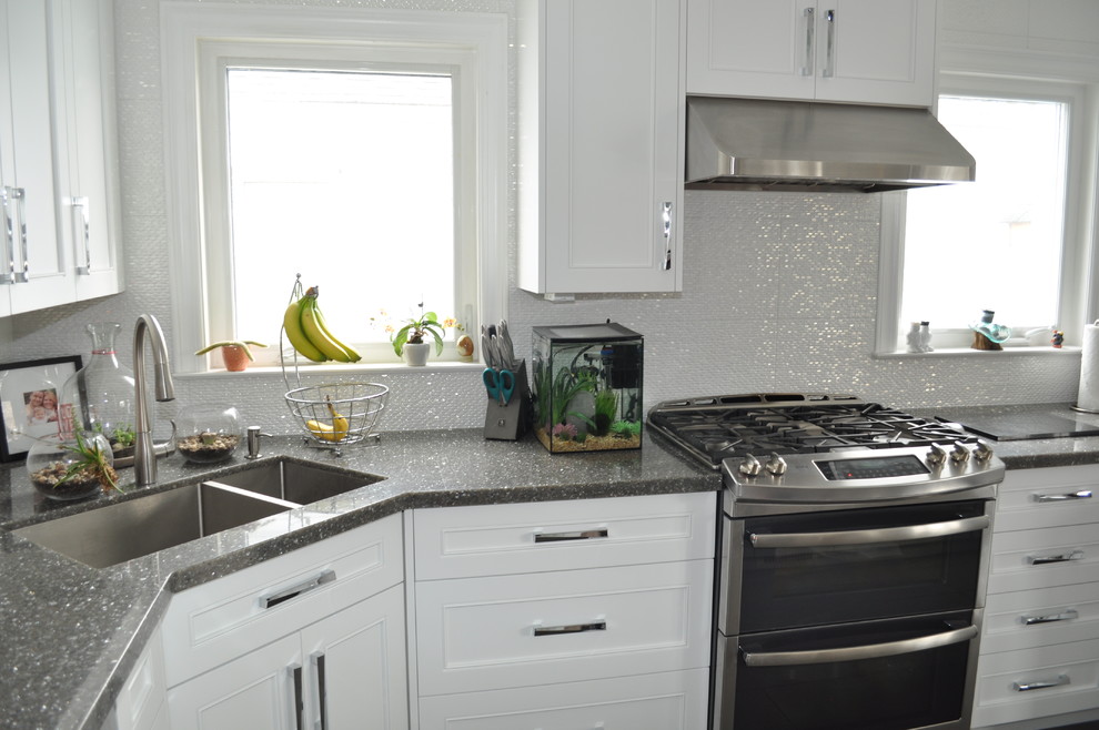 Example of a small transitional u-shaped porcelain tile and gray floor eat-in kitchen design in Toronto with an undermount sink, shaker cabinets, white cabinets, quartz countertops, white backsplash, porcelain backsplash, stainless steel appliances and an island