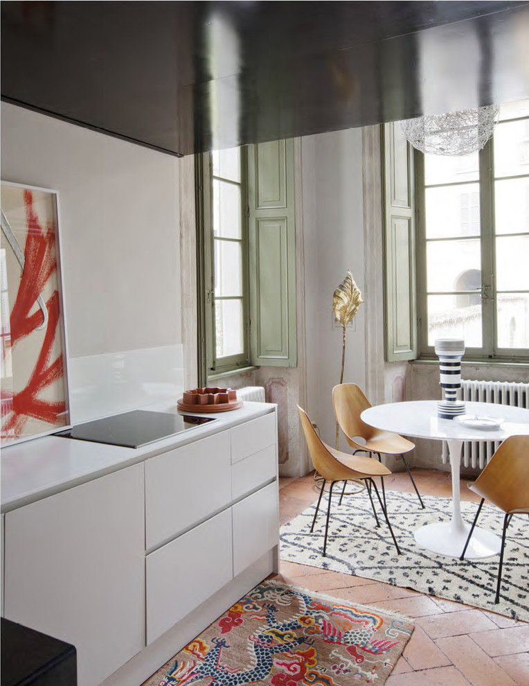 Design ideas for a large modern kitchen/dining combo in Milan with white walls and brick floors.