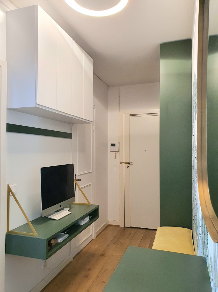 Exemple d'une entrée tendance de taille moyenne avec un couloir, un mur vert, parquet clair, une porte simple, une porte blanche, un sol beige et du papier peint.