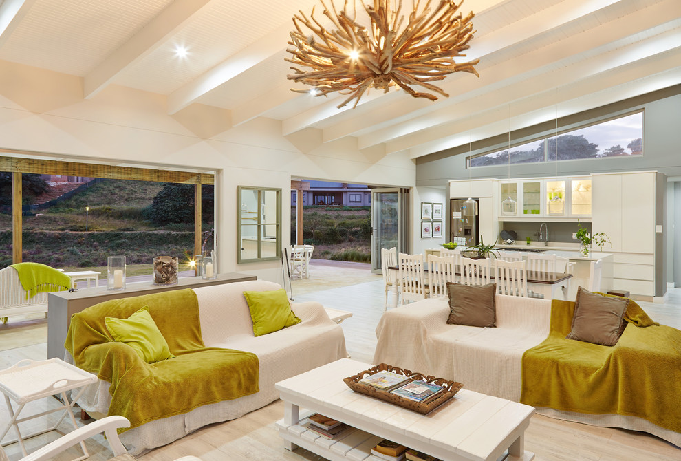 Contemporary open concept living room in Other with white walls and beige floor.