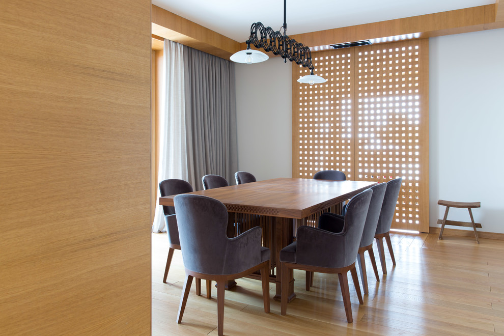 Photo of a contemporary dining room in Moscow with white walls, light hardwood floors and beige floor.