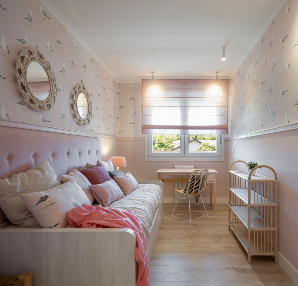 Esempio di una cameretta per bambini da 4 a 10 anni chic di medie dimensioni con pareti rosa, pavimento in laminato, pavimento beige e carta da parati