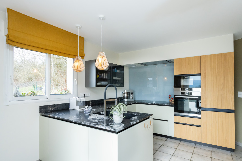 Inspiration for a medium sized contemporary u-shaped open plan kitchen in Nancy with a double-bowl sink, flat-panel cabinets, green cabinets, granite worktops, grey splashback, glass sheet splashback, integrated appliances, ceramic flooring, a breakfast bar, grey floors, black worktops and a coffered ceiling.