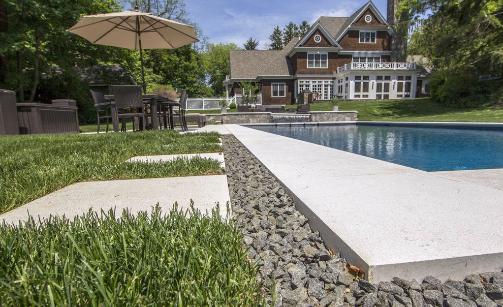 Photo of a large modern front yard rectangular infinity pool in New York with a hot tub and natural stone pavers.