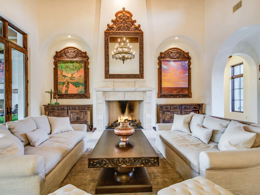 Mediterranean living room in Austin with white walls, a standard fireplace, a stone fireplace surround and white floor.