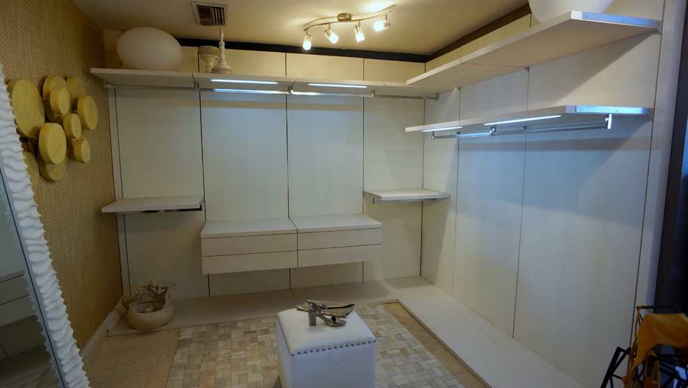 Inspiration for a large modern women's walk-in wardrobe in Miami with open cabinets, white cabinets and limestone floors.