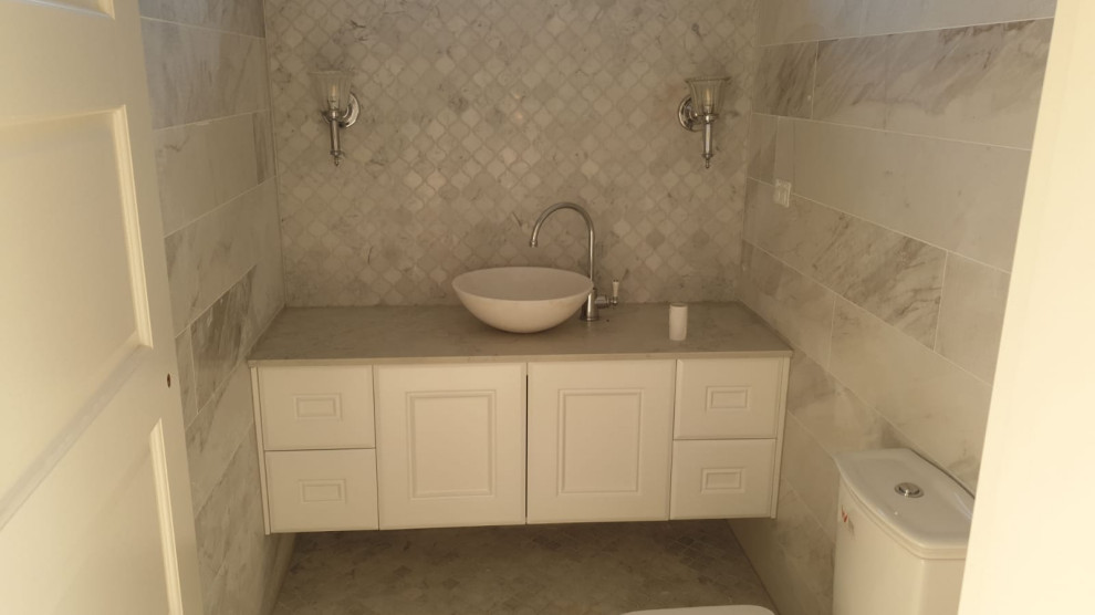 Photo of a medium sized cloakroom in Other with shaker cabinets, white cabinets, beige tiles, quartz worktops, beige worktops and a floating vanity unit.