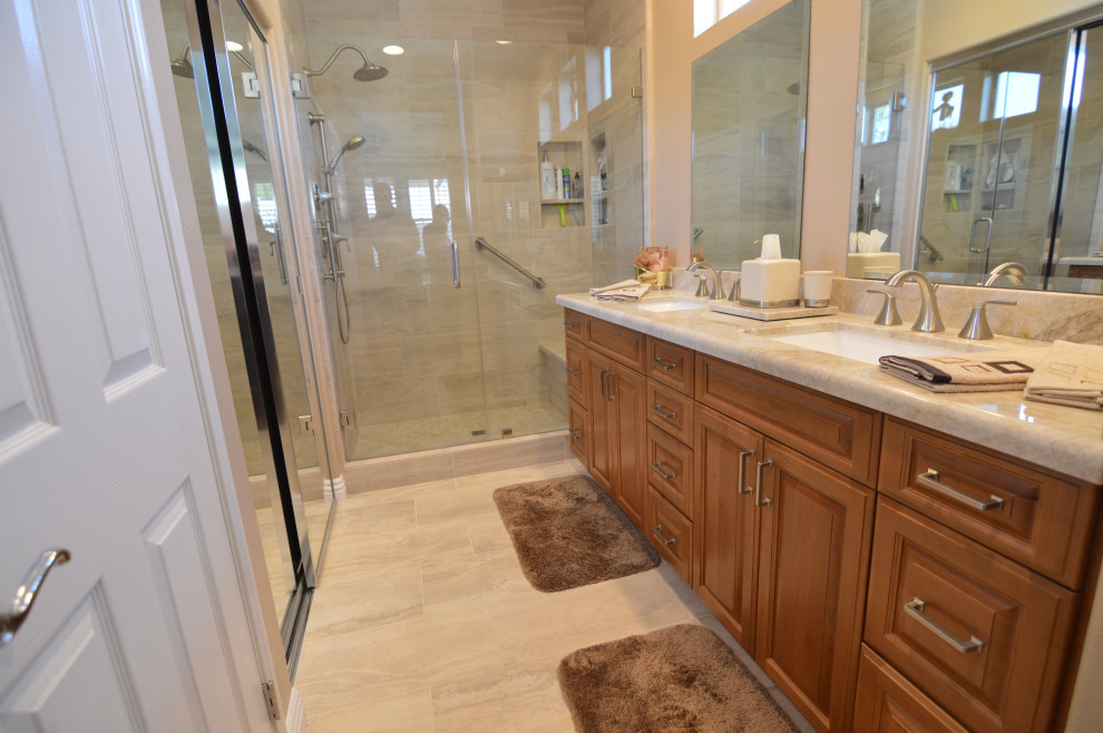 Photo of a mid-sized traditional kids bathroom in Los Angeles with raised-panel cabinets, medium wood cabinets, an alcove shower, beige walls, porcelain floors, an undermount sink, quartzite benchtops, beige floor, a hinged shower door, beige benchtops, a double vanity and a built-in vanity.