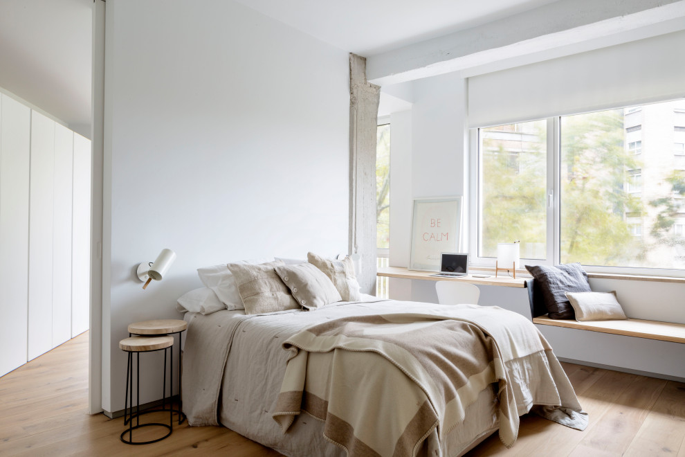 Imagen de dormitorio minimalista con paredes blancas, suelo de madera clara y suelo beige