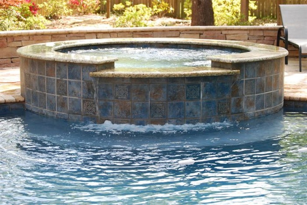 Mid-sized backyard stone and rectangular natural hot tub photo