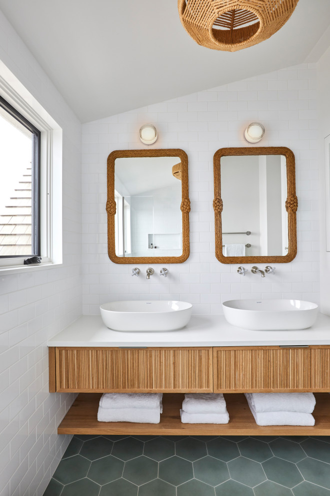 Maritimes Badezimmer mit hellen Holzschränken, weißen Fliesen, Metrofliesen, Quarzwerkstein-Waschtisch, weißer Waschtischplatte, Doppelwaschbecken und eingebautem Waschtisch in New York