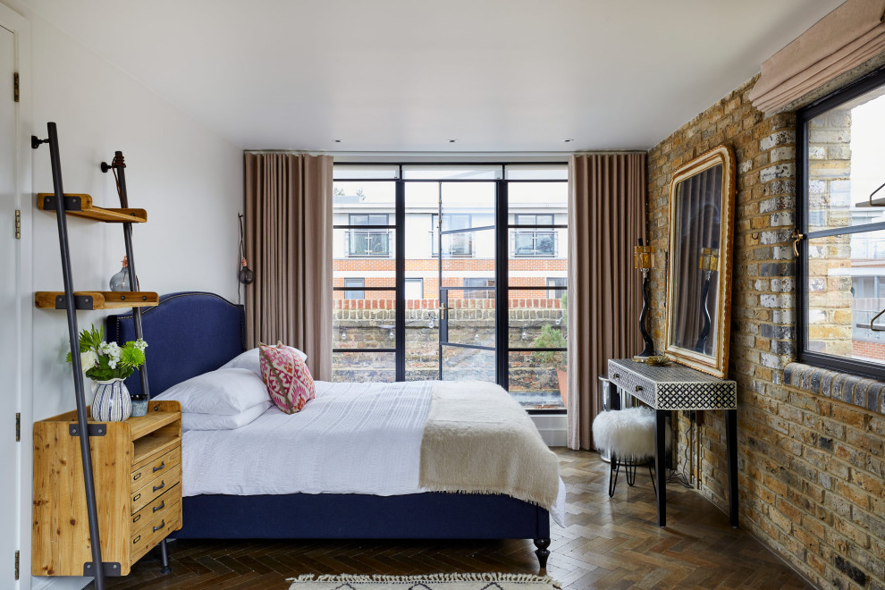 Medium sized urban bedroom in London with medium hardwood flooring.