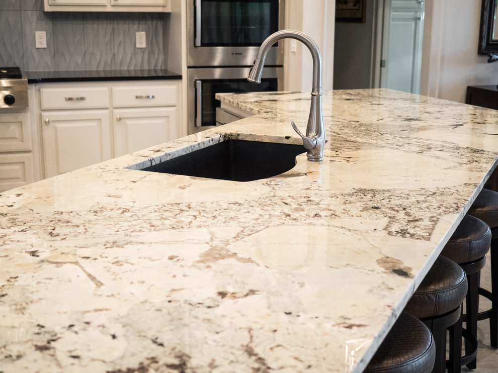 Eat-in kitchen - large transitional u-shaped eat-in kitchen idea with an undermount sink, raised-panel cabinets, white cabinets, granite countertops, gray backsplash, ceramic backsplash, stainless steel appliances and two islands