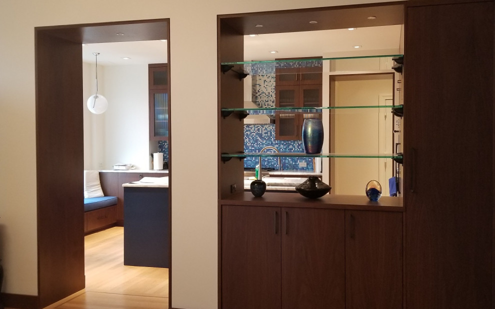 This is an example of a large midcentury open plan kitchen in New York with an undermount sink, flat-panel cabinets, medium wood cabinets, quartzite benchtops, blue splashback, mosaic tile splashback, panelled appliances, light hardwood floors, with island and white benchtop.