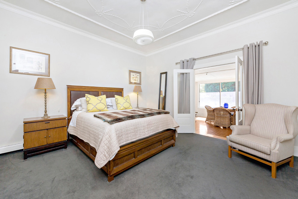 This is an example of a country guest bedroom in Other with white walls, carpet and grey floor.