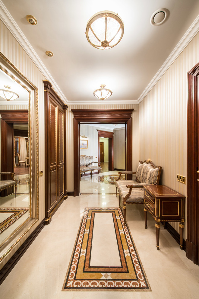 This is an example of a large traditional hallway in Moscow with beige walls and marble floors.