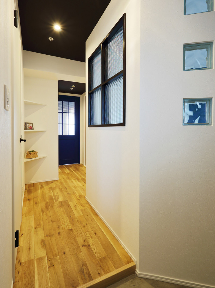 Imagen de recibidores y pasillos actuales con paredes blancas, suelo de madera en tonos medios, suelo beige, papel pintado y papel pintado