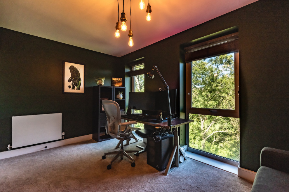 Ejemplo de despacho industrial de tamaño medio con paredes verdes, moqueta, escritorio independiente y suelo gris
