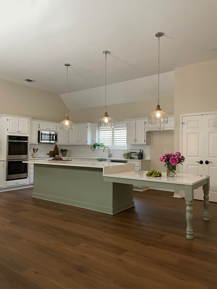 Kitchen - l-shaped kitchen idea with a single-bowl sink, quartz countertops, white backsplash, subway tile backsplash, stainless steel appliances, an island and white countertops