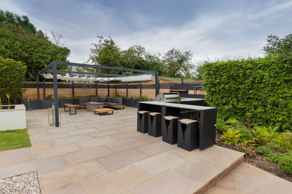 Großer Moderner Patio hinter dem Haus mit Outdoor-Küche, Natursteinplatten und Gazebo in Sonstige