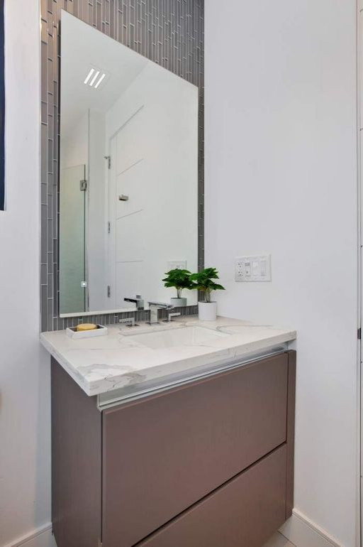 Design ideas for a small modern powder room in San Francisco with flat-panel cabinets, brown cabinets, a two-piece toilet, gray tile, porcelain tile, white walls, porcelain floors, an undermount sink, engineered quartz benchtops, beige floor, white benchtops and a floating vanity.