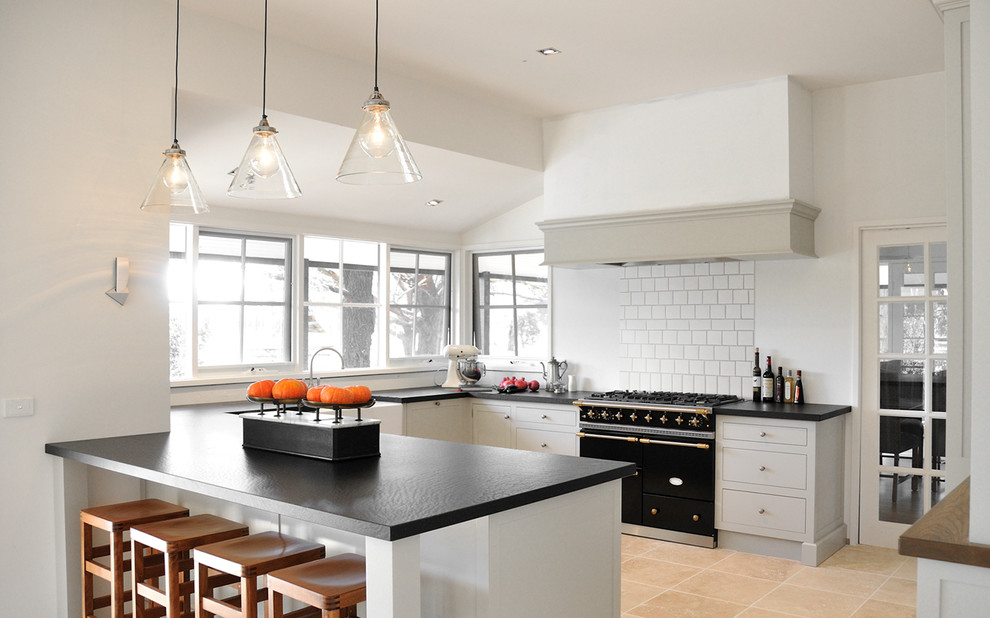 This is an example of a country kitchen in Melbourne with black appliances, grey cabinets and beige floor.