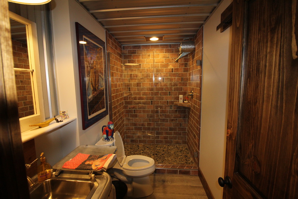 Photo of a mid-sized country walk-out basement in Other with beige walls, laminate floors, a wood stove and brown floor.