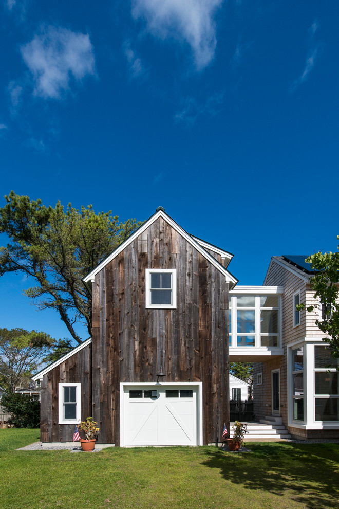 This is an example of a beach style attached one-car garage in Boston.