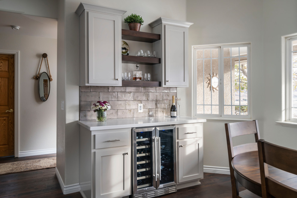 Design ideas for an expansive transitional single-wall home bar in Los Angeles with shaker cabinets, grey cabinets, quartz benchtops, grey splashback, ceramic splashback, vinyl floors, brown floor and white benchtop.