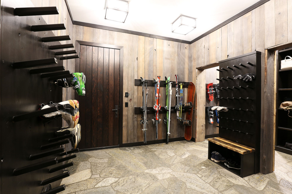 Large mountain style gray floor mudroom photo with a dark wood front door