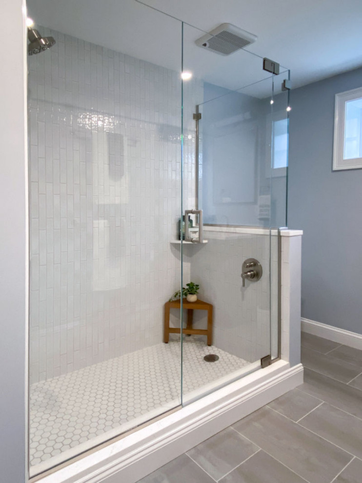 Corner shower - transitional white tile and ceramic tile porcelain tile, gray floor and single-sink corner shower idea in Boston with shaker cabinets, gray cabinets, a one-piece toilet, gray walls, an undermount sink, quartz countertops, a hinged shower door, white countertops and a built-in vanity