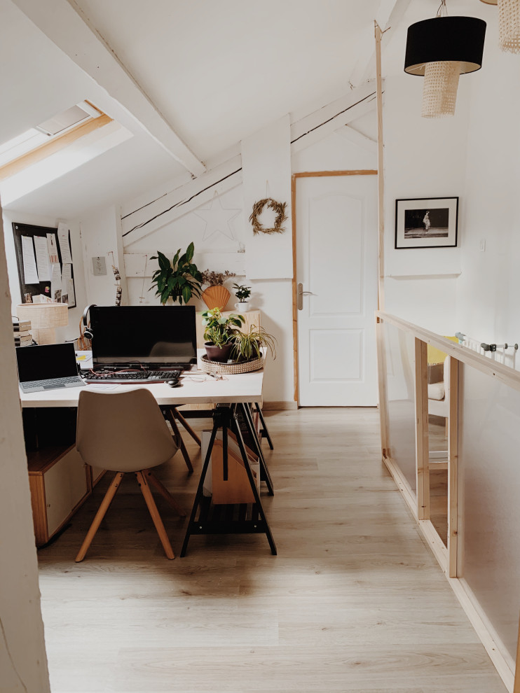 Modelo de despacho blanco escandinavo de tamaño medio sin chimenea con paredes blancas, suelo laminado, escritorio empotrado, suelo gris y vigas vistas
