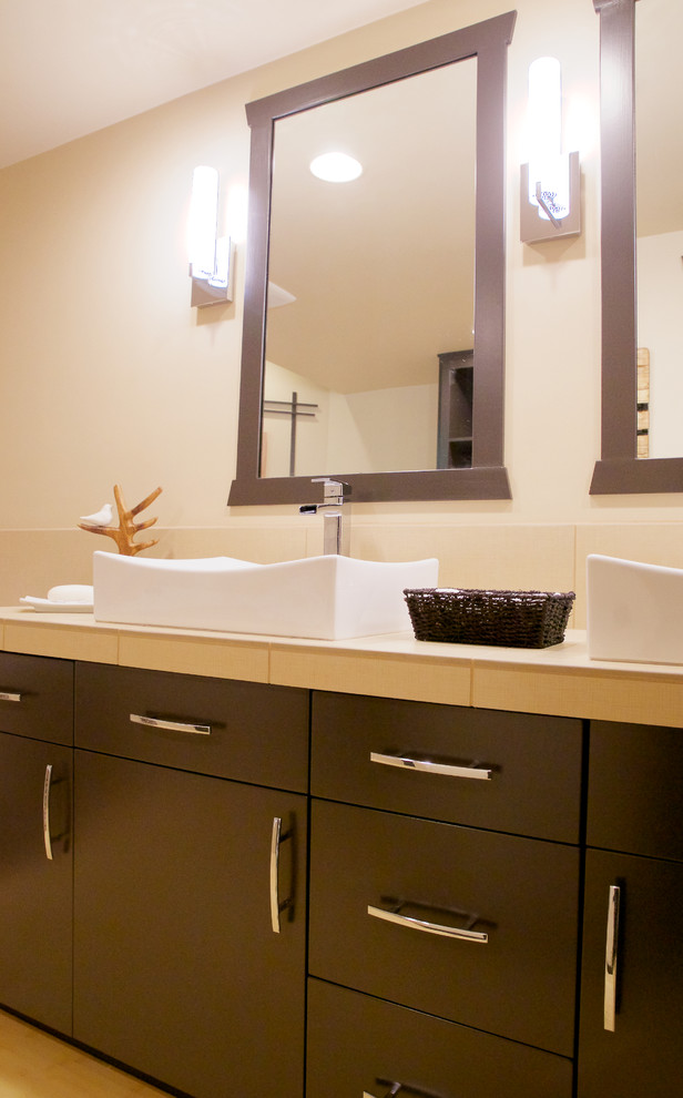 Design ideas for an asian bathroom in Portland with a vessel sink, flat-panel cabinets, black cabinets, tile benchtops, beige tile and porcelain tile.