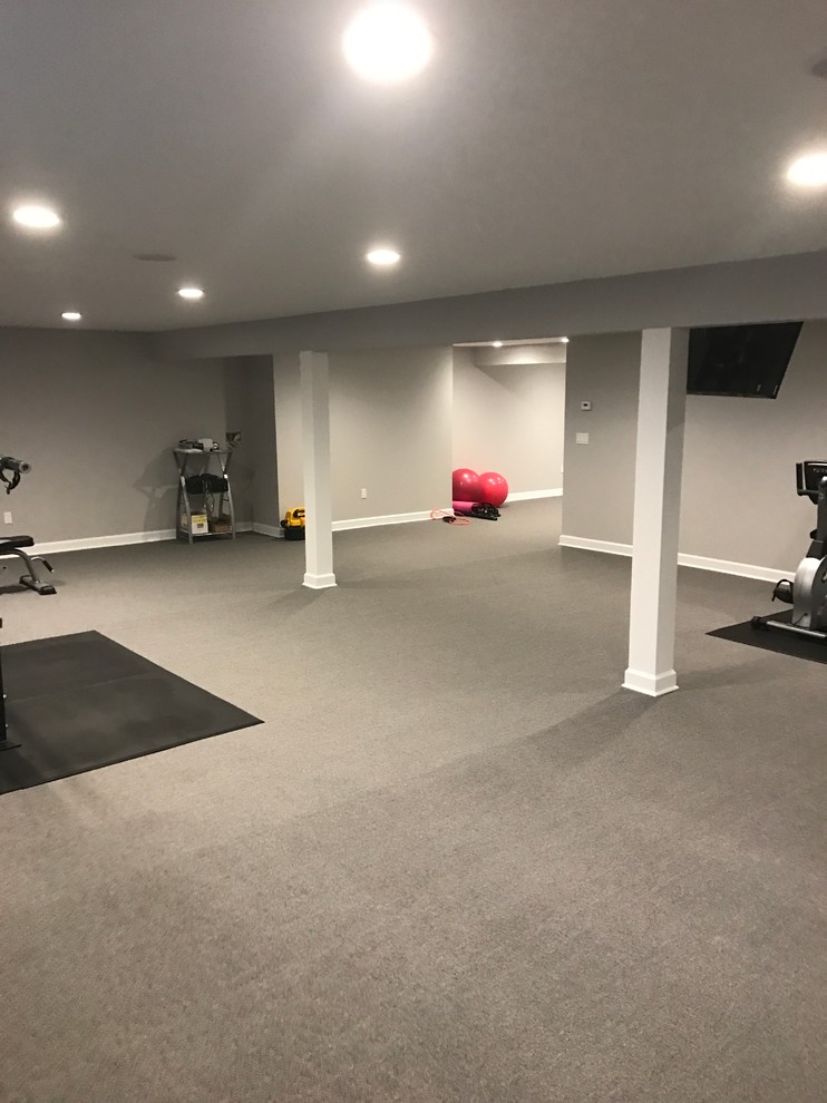 Photo of a large traditional home weight room in New York with grey walls, carpet and grey floor.
