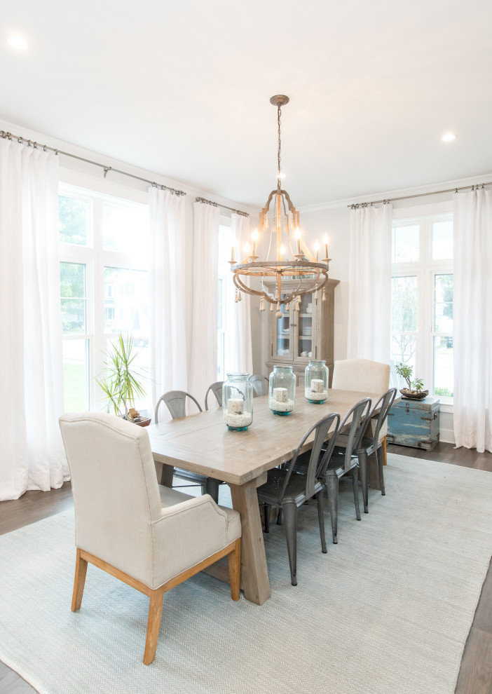 Inspiration for a coastal medium tone wood floor and brown floor enclosed dining room remodel with white walls and no fireplace