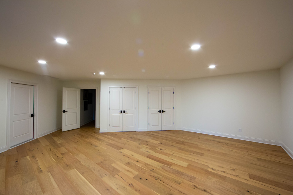 Photo of a large classic look-out basement in Indianapolis with beige walls, laminate floors and brown floors.