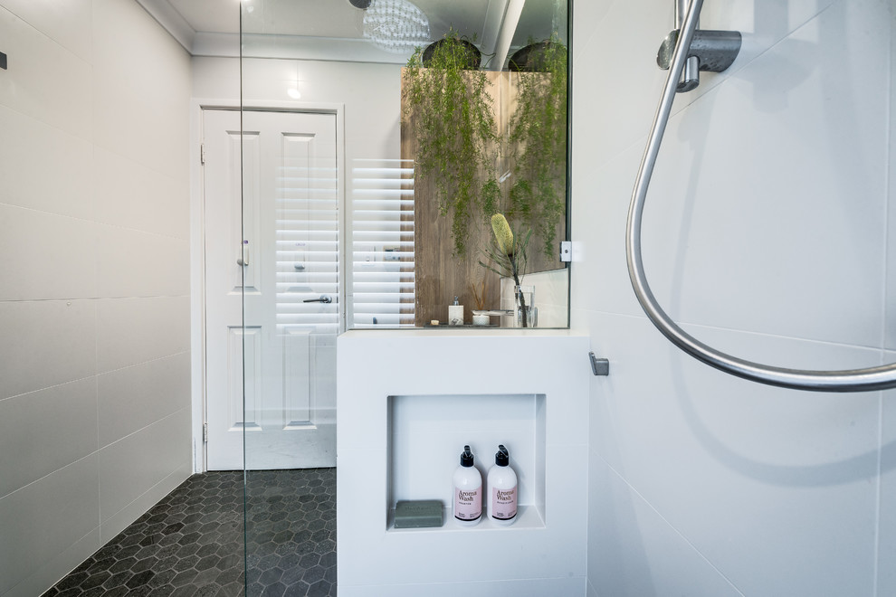 This is an example of a mid-sized contemporary master bathroom in Perth with recessed-panel cabinets, medium wood cabinets, a drop-in tub, an open shower, white tile, porcelain tile, white walls, mosaic tile floors, an undermount sink, solid surface benchtops, grey floor, an open shower and multi-coloured benchtops.